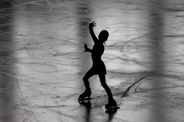 Silhouette de patineuse artistique executant une figure sur la glace